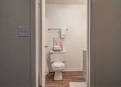 Thumbnail 3 of 15 - A white toilet in a small bathroom.