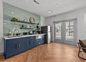 Thumbnail 18 of 25 - A kitchen with a blue cabinetry and a glass wall.