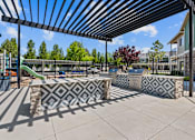 Thumbnail 9 of 25 - A playground with a black and white patterned bench under a black and white striped awning.