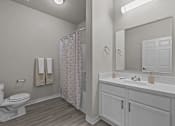 Thumbnail 24 of 25 - A white bathroom with a toilet, sink, and shower.
