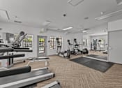 Thumbnail 19 of 25 - A gym with treadmills, exercise bikes, and other equipment.