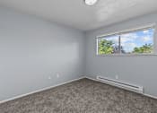 Thumbnail 6 of 34 - A room with a window showing trees and a blue sky.