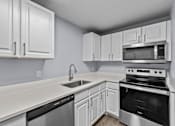 Thumbnail 3 of 34 - A kitchen with white cabinets and appliances.