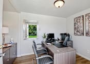 Thumbnail 23 of 34 - A home office with a desk, chairs, and a window.
