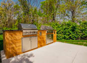 Thumbnail 13 of 61 - A wooden outdoor kitchen with a grill and sink.