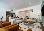 Thumbnail 2 of 61 - A modern living room with a white couch, orange chairs, and a fireplace.