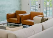 Thumbnail 8 of 61 - A living room with a white couch and two brown chairs.