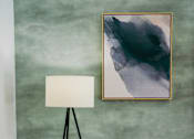 Thumbnail 9 of 61 - A white couch with a green pillow and a painting on the wall.