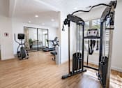 Thumbnail 12 of 61 - A gym with a treadmill, elliptical trainer and a stationary bike.
