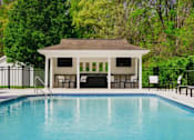 Thumbnail 14 of 61 - A pool with a pavilion in the background.