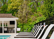 Thumbnail 17 of 61 - A poolside area with sun loungers and a pool.