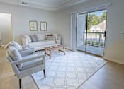 Thumbnail 29 of 61 - A living room with a grey couch and a white rug.