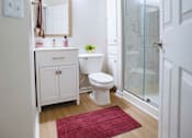 Thumbnail 31 of 61 - A white bathroom with a toilet, sink, and shower.