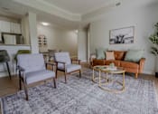 Thumbnail 35 of 61 - A living room with a grey rug and a gold coffee table.