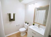 Thumbnail 39 of 61 - A white bathroom with a toilet, sink, and mirror.