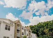 Thumbnail 43 of 61 - Apartment building with trees in the background.