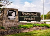 Thumbnail 50 of 61 - A sign for Blendon Woods Metro Park is displayed in front of a stone pillar.
