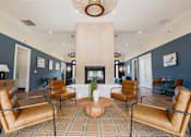 Thumbnail 3 of 36 - A living room with a fireplace and brown leather chairs.