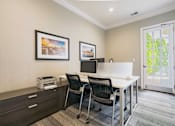 Thumbnail 8 of 36 - A room with a desk, chairs, and pictures on the wall.