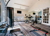 Thumbnail 10 of 36 - A gym with a variety of equipment including treadmills, weights, and exercise machines.