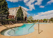 Thumbnail 15 of 36 - A swimming pool with a slide in front of a residential building.
