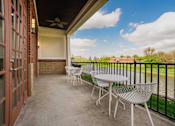 Thumbnail 20 of 36 - A patio with a table and chairs overlooking a body of water.