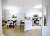 Thumbnail 26 of 36 - A modern kitchen with a dining table and chairs.