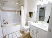 Thumbnail 31 of 36 - A white bathroom with a toilet, sink, and bathtub.