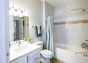 Thumbnail 32 of 36 - A white bathroom with a white toilet, sink, and bathtub.