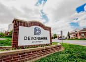 Thumbnail 36 of 36 - A sign for Devonshire Apartments is displayed in front of a grassy area.