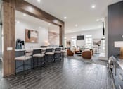 Thumbnail 7 of 21 - A modern kitchen with a long table and chairs.