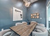 Thumbnail 8 of 21 - A wooden table is surrounded by grey chairs in a room.