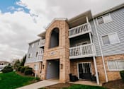 Thumbnail 4 of 42 - A two-story apartment building with a balcony and a garage door.