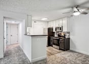 Thumbnail 7 of 42 - A kitchen with a white counter and a black refrigerator.