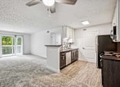Thumbnail 10 of 42 - A spacious kitchen with a bar area and a ceiling fan.
