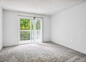 Thumbnail 12 of 42 - A room with a carpeted floor and a sliding glass door leading to a balcony.