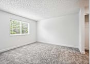 Thumbnail 14 of 42 - A room with a window and carpeted floor.