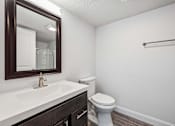 Thumbnail 16 of 42 - A white toilet sits next to a sink in a bathroom.