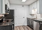 Thumbnail 18 of 42 - A kitchen with black appliances and white cabinets.