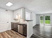 Thumbnail 19 of 42 - A kitchen with white cabinets and a black dishwasher.