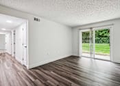 Thumbnail 20 of 42 - A room with a sliding glass door leading to a backyard.