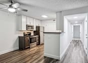 Thumbnail 21 of 42 - A kitchen with wood floors and white walls.