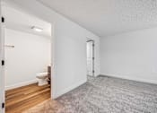 Thumbnail 25 of 42 - A white bathroom with a toilet and a carpeted floor.