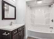 Thumbnail 26 of 42 - A white sink with a silver faucet and a brown mirror above it.
