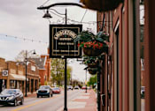 Thumbnail 36 of 42 - A sign for a brewery hangs over a sidewalk.