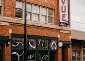 Thumbnail 38 of 42 - A red brick building with a black sign that says VUE on it.