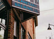 Thumbnail 40 of 42 - A sign for a brewery hangs on a building.