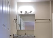 Thumbnail 16 of 27 - A white bathroom with a toilet, sink, and mirror.