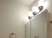 Thumbnail 19 of 27 - A bathroom with a marble counter top and a mirror with lights.