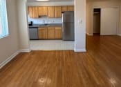 Thumbnail 6 of 8 - A kitchen with wooden cabinets and a refrigerator.